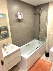 a bathroom with a tub and a sink and a shower at Grace Studio in London +23 photos