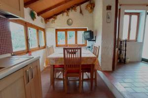 a kitchen with a table with chairs and a tv at Family Friendly Rosa House Amazing View - Happy Rentals in Barga