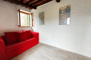 a red couch in a room with a window at Family Friendly Rosa House Amazing View - Happy Rentals in Barga +45 photos