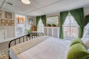 a bedroom with a large bed with green curtains at Top-Floor 1BR in Historic Capitol Hill in Washington