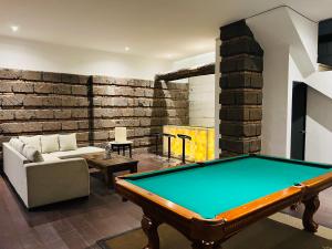 sala de estar con mesa de billar y sofá en QA Hotel, en San Luis Potosí