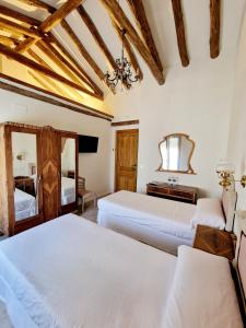 a bedroom with two beds and a mirror at La Casa de la Rufi in Colmenar de Oreja