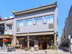 北京IMMERSING Hotel Beijing Tiananmen Square Branch的一栋建筑前停着一辆摩托车