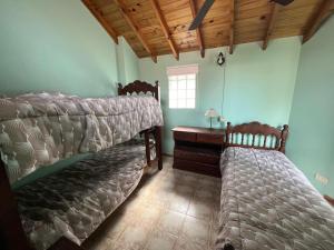 ein Schlafzimmer mit zwei Betten und einem Schreibtisch und einem Fenster in der Unterkunft Duplex frente al Mar en Villa Gesell in Villa Gesell