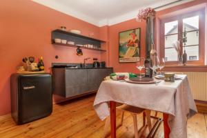 a dining room with a table and a kitchen at City-Loft in Villa 100und10 - Charmantes Dachstudio beim Lendkanal in Klagenfurt
