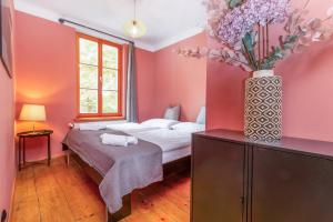 a bedroom with a bed and a vase of flowers at City-Loft in Villa 100und10 - Charmantes Dachstudio beim Lendkanal in Klagenfurt