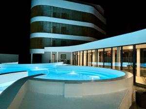 a swimming pool in front of a building at night at Baltic Waves Resort & SPA Międzyzdroje 3 in Międzyzdroje