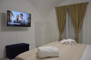 a bedroom with a bed with a tv on the wall at MOUSUITE in Catania