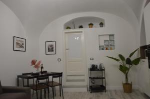 un soggiorno con tavolo e porta bianca di MOUSUITE a Catania