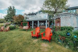 a house with chairs and a swing in the yard at Along River Ridge in Calgary