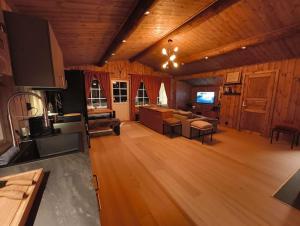 a large kitchen and living room with wooden walls and wooden floors at OlaHytta - Cozy cabin close to kvitfjell in Tromsnes