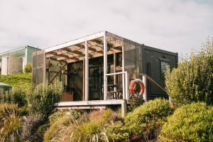 a tiny house sitting on top of a hill at Beach Front Oasis - Catlins, Jacks Bay in Hinahina