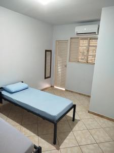 a room with a blue bed and a air conditioner at Apto 6 ótimo local próximo shopping in Campo Grande