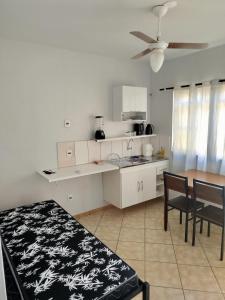 a white kitchen with a table and a dining room at Apto 6 ótimo local próximo shopping in Campo Grande