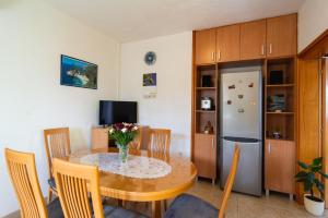 a dining room with a table and a refrigerator at Apartment Ivope in Splitska
