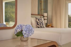 a vase of purple flowers on a table in a living room at Penha Longa Resort in Sintra