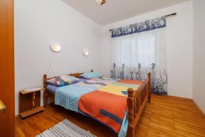 ein Schlafzimmer mit einem Bett mit einer blauen und orangen Decke in der Unterkunft Apartments Zvonimir in Senj