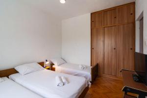 two beds in a hotel room with a television at Apartment Ivope in Splitska