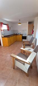 ein Wohnzimmer mit zwei Stühlen und eine Küche in der Unterkunft Aparts Casas Del Centro-El Chaltén in El Chalten