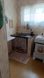 大普拉亚Kitnet Temporada Praia Grande SP - Completa com Wi-fi, garagem rotativa, 1 quadra da praia - no centro comercial Boqueirão的带水槽和炉灶的厨房