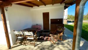 a patio with a table and chairs on a porch at Miracle Houses Къщи за гости Чудеса in Varshets