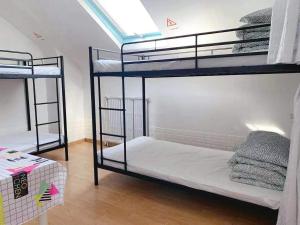 two bunk beds in a room with a window at Rainbow Villa, One bed in shared dormitory room, please choose male or female room correctly, not mixed, check in from 16h00 to 23h50 in Villejuif
