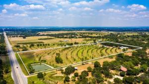 an aerial view of a field with trees and a road at Pecan Farm Haus in Fredericksburg