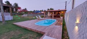 a backyard with a hot tub on a wooden deck at Casa Ilha de Itaparica Bahia in Ilha de Itaparica