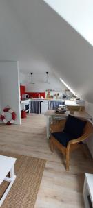 a living room with a table and a kitchen at Escapade en Bretagne in Penmarcʼh