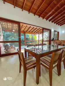 a dining room with a glass table and chairs at Casa espaçosa Ilhabela perto da praia das Conchas in Ilhabela