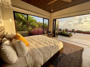 a bedroom with a large bed with a view of the ocean at RESOL Secluded Ocean-view luxury in the Jungle in Uvita