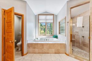 a bathroom with a tub and a toilet and a window at Highlands Ridge Retreat Massive 9 BDR Estate in Breckenridge +37 photos