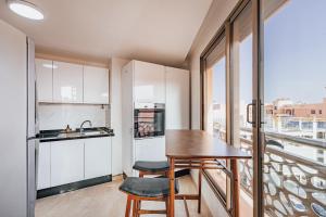 a kitchen with a table and chairs and a balcony at Migdal Gueliz Apart Hôtel in Marrakesh