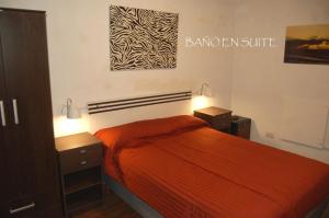 a bedroom with a orange bed and two night stands at Acantilados en Familia in Mar del Plata