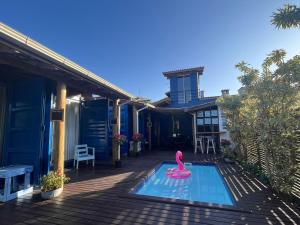 a pink swan in a swimming pool on a house at Capim Limão Containers do Rosa in Praia do Rosa