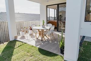 TerranoraEntire Unit with Own Entrance near Gold coast Airport for family holidays 04 Beds 2 rooms的露台上有一张桌子和几把椅子