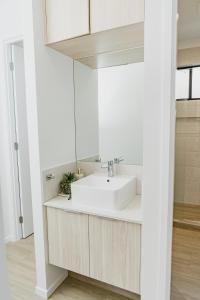 TerranoraEntire Unit with Own Entrance near Gold coast Airport for family holidays 04 Beds 2 rooms的带白色水槽和镜子的浴室