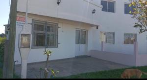 a dog standing in front of a white building at Departamento federación in Federación