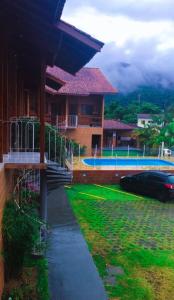 ein Haus mit einem Swimmingpool davor in der Unterkunft Kitnet na Martim de Sá - Caraguatatuba in Caraguatatuba