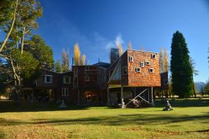 a large brick house on a grass field at Casa Bahía Patagonia in Bahía Murta