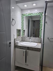 a bathroom with a sink and a mirror at CIG Hostel in Goiânia