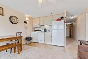 Una cocina con un refrigerador blanco y una mesa. en ML355 Slope Side Getaway EZ Parking Near Village WiFi, en Snowshoe