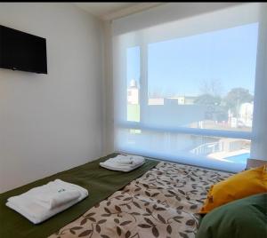 una habitación con una cama y una ventana grande en Agua de Vida, en Chajarí