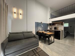 ein Wohnzimmer mit einem Sofa und einem Esstisch in der Unterkunft LOFT MUNDI - Conforto no Centro com Ar Condicionado in Águas de Lindóia