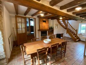 une cuisine et une salle à manger avec une table et des chaises en bois dans l'établissement Gîte écologique familial en campagne, idéal pour sports et nature - FR-1-410-452, à Moulins-le-Carbonnel