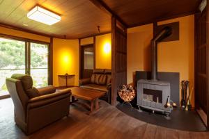 un soggiorno con camino e divano di Natural Hot Spring Inn Choseian - 長生庵 - a Shirahama