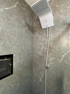 a shower with a shower head in a bathroom at Apto aconchegante no Centro in Jaguarão +59 photos
