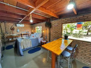 a room with a bed and a wooden table at Pousada Águas Claras/Canastra in Delfinópolis
