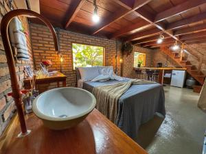 a bathroom with a sink and a bed in a room at Pousada Águas Claras/Canastra in Delfinópolis +65 photos