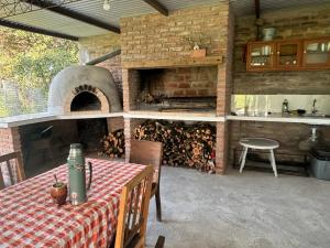 an outdoor kitchen with a pizza oven and a table with a table sidx sidx at Casa de campo in Carmelo